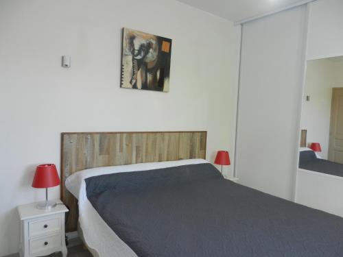 ドラギニャンにあるL'Oliveraieのベッドルーム1室(大型ベッド1台、木製ヘッドボード付)