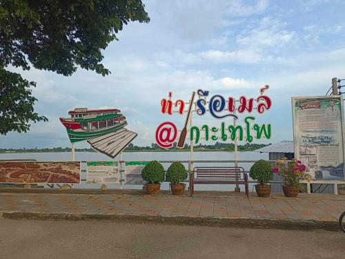 a sign for a seafood restaurant with a bench at บ้านแม่อุทัยธานี Baanmae Uthaithani in Uthai Thani