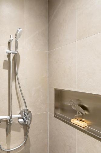 a shower with a bird on a shelf in a bathroom at Richter Altstadtappartements in Goslar