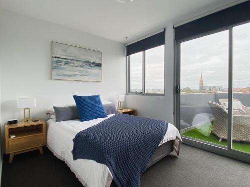 1 dormitorio con cama y ventana grande en Penthouse 3 bedroom 6 guests 2 bathrooms en Melbourne