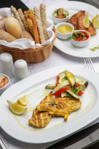 a table with three plates of food on it at Astoria Hotel Thessaloniki in Thessaloniki