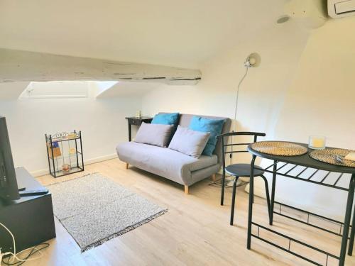 un salon avec un canapé et une table dans l'établissement Palais des festivals et rue d'Antibes charme mansardes, à Cannes