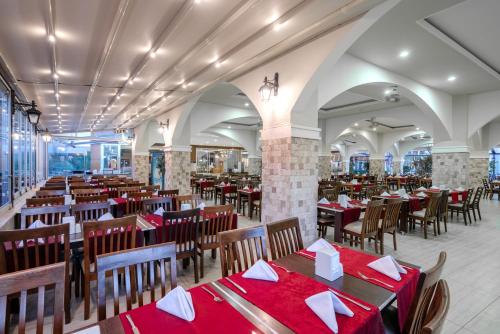 a restaurant with tables and chairs with red tablecloths at SUN HEAVEN FAMILY & SPA in Alanya