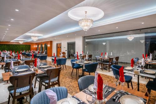 a dining room with tables and chairs and a chandelier at SUN HEAVEN FAMILY & SPA in Alanya