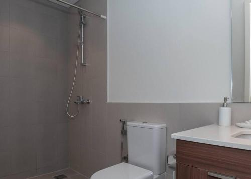 a bathroom with a toilet and a sink and a shower at StoneTree - Furnished 1BR in Peaceful Community in Dubai