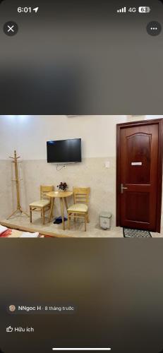 a room with a table and two chairs and a tv at Hotel Đại Dương in Thuan An
