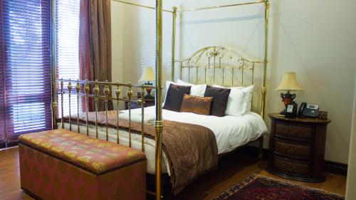 a bedroom with a four poster bed and a stool at Candlewoods Guesthouse in Irene