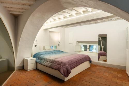 een slaapkamer met een bed in een witte kamer bij Elisa loft davanti alle Mura Lucca in Lucca
