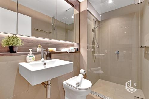 a bathroom with a sink and a toilet and a shower at Rest SkyHigh Melbourne Qtr Collection in Melbourne