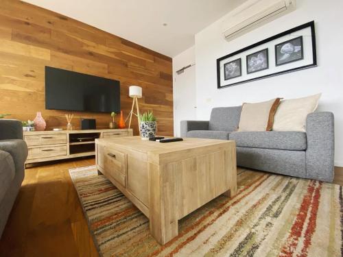 a living room with a couch and a tv at Penthouse 3 bedroom 6 guests 2 bathrooms in Melbourne