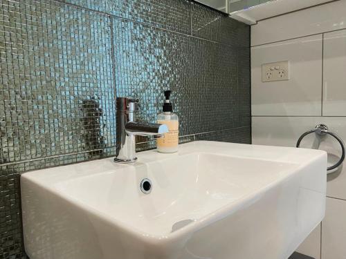 un lavabo con una botella de jabón. en Penthouse 3 bedroom 6 guests 2 bathrooms en Melbourne
