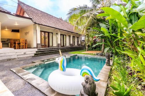 einen Pool im Hinterhof eines Hauses mit aufblasbarer Badewanne in der Unterkunft Uda Suite Guest House 1 in Ubud