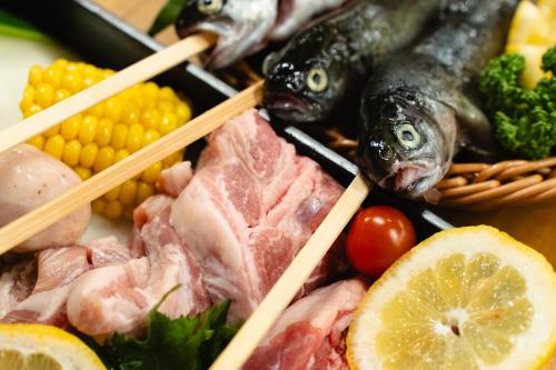 a plate of food with fish and vegetables and chopsticks at ウッドデザインパーク瀬戸 in Seto