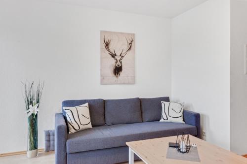 a living room with a blue couch and a table at WINETIME - für 3 - nähe Madenburg - Burg Landeck in Eschbach