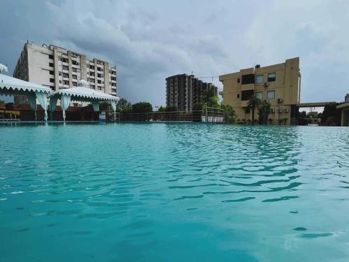 une grande piscine d'eau bleue devant les bâtiments dans l'établissement 7R Resort, à Jaipur