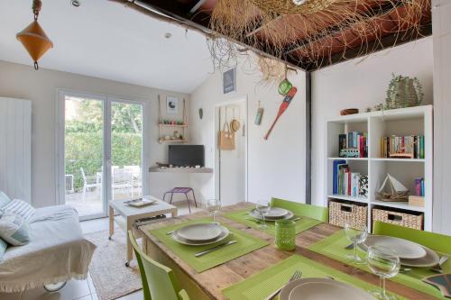 une salle à manger avec une table et des chaises vertes dans l'établissement La Sanaryenne - Joli appt proche plage, à Sanary-sur-Mer