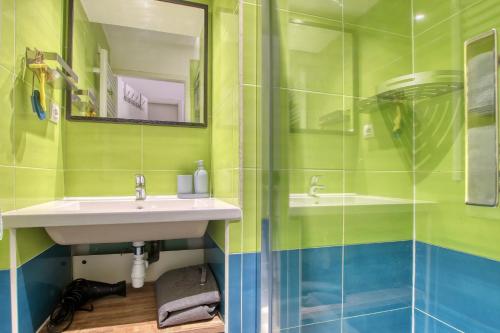 La salle de bains verte est pourvue d'un lavabo et d'un miroir. dans l'établissement La Sanaryenne - Joli appt proche plage, à Sanary-sur-Mer