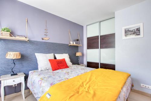 une chambre avec un lit avec un oreiller rouge dessus dans l'établissement La Sanaryenne - Joli appt proche plage, à Sanary-sur-Mer