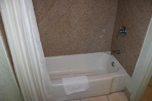 baño con bañera blanca junto a la pared en Sportsman's Motel, en Eagle Lake