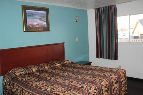1 dormitorio con 1 cama en una habitación azul en Sportsman's Motel, en Eagle Lake