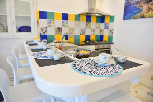 a kitchen with a table with cups and plates on it at LA CASA DEL CAPITANO furore amalfi coast in Furore