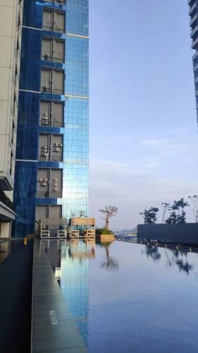 une piscine en face d'un grand bâtiment dans l'établissement 1 BR @ Roseville Apartment BSD, à Dadap