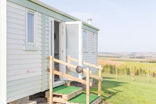 une petite maison avec un escalier menant à la porte dans l'établissement Mobil Home à la Ferme, à Fiennes
