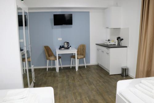 Zimmer mit einer Küche und einem Tisch mit Stühlen in der Unterkunft Apartments & Pension Burglesum in Bremen