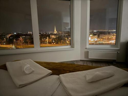a bed with two pillows in a room with two windows at Sky Apartments 506 in Plzeň
