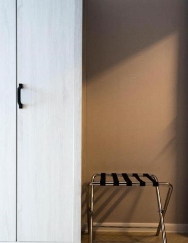 a white door with a metal stool in a room at FOX Hotel Glenmarie Shah Alam in Shah Alam