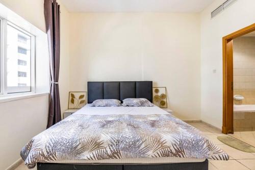 una camera da letto con letto con testiera nera e finestra di Amazing 1BR Apt at silicon oasis Dubai for family a Dubai