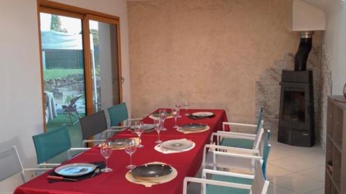 comedor con mesa roja y sillas en Gite Paradis des Oiseaux du jardin, en Quédillac