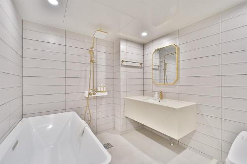 uma casa de banho branca com um lavatório e um espelho em Hotel Palace Gyeongju em Gyeongju