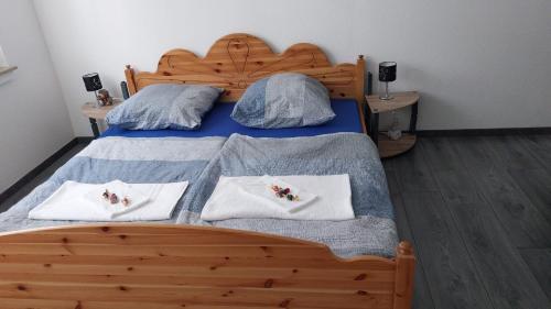 a bedroom with a wooden bed with two pillows at Sauna-Schmied in Weißenfels