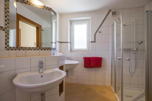 a white bathroom with a sink and a shower at Appart Ambiente in Zell am Ziller