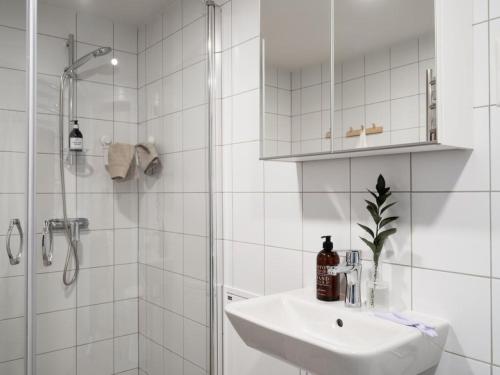 a white bathroom with a sink and a shower at Waterfront Cabins in Gothenburg