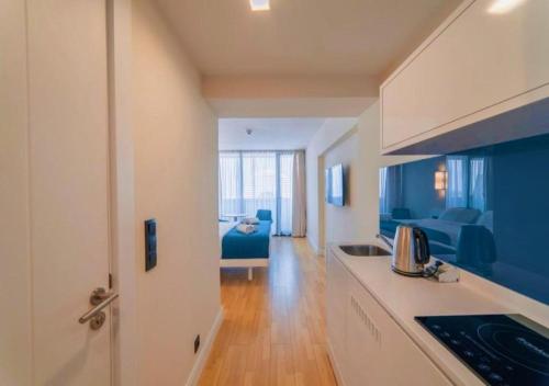 uma cozinha e uma sala de estar com um sofá azul em Beachfront Apartments Batumi em Batumi