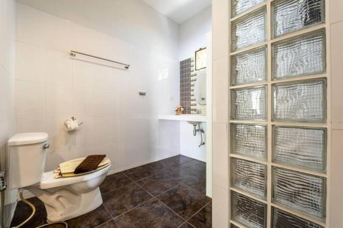 a white bathroom with a toilet and a window at 3 Bedroom Pool Villa Close to City Center! S102 in Hua Hin