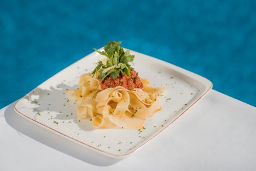 a plate of pasta on a blue background at Aquafun By Grand Mogador Agdal in Marrakech