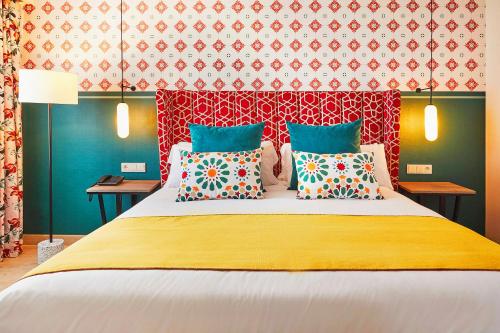 a bedroom with a large bed with colorful pillows at Hesperia Sevilla in Seville