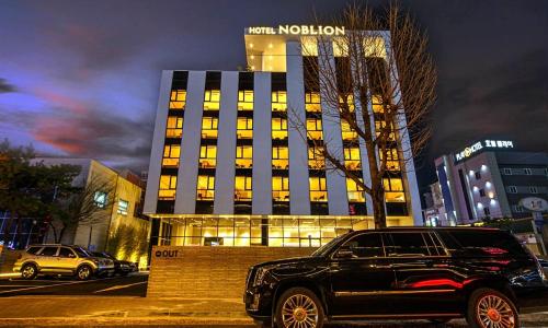 a black car parked in front of a building at Pohang Hotel Noblion in Pohang