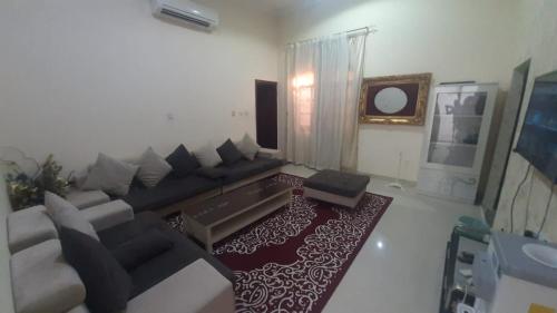 - un salon avec un canapé et une télévision dans l'établissement العين الهيلي مصباح بيت 3, à Al-Aïn