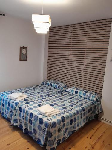 a bedroom with a bed with a blue comforter at Apartamento la catedral in Santo Domingo de la Calzada