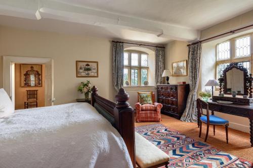 a bedroom with a bed and a desk and a mirror at Pentrehobyn Hall in Wrexham