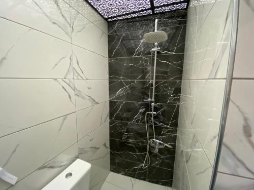 a bathroom with a shower with black marble tiles at MY WORLD OTEL ÇORUM in Corum