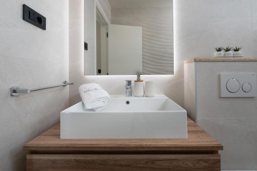 y baño con lavabo blanco y espejo. en Villa Perla, en Nova Vas