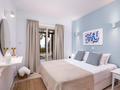 a bedroom with a large bed with blue walls at Kyma I - Beachfront Residence At Latsi in Polis Chrysochous