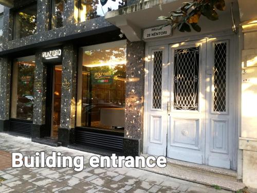 a building entrance with the words building entrance on it at Central Loft in Tirana