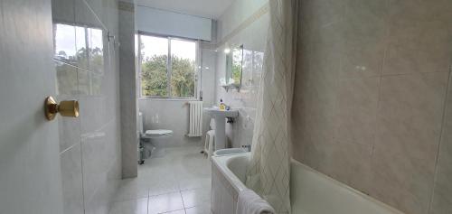 een badkamer met een bad, een toilet en een wastafel bij Hotel A Estrada Rooms in A Estrada