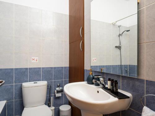 a bathroom with a sink and a toilet and a mirror at Kyma I - Beachfront Residence At Latsi in Polis Chrysochous